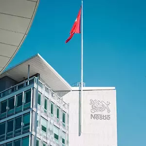 Nestlé-Hauptgebäude mit Firmenlogo und Flagge am Unternehmensstandort