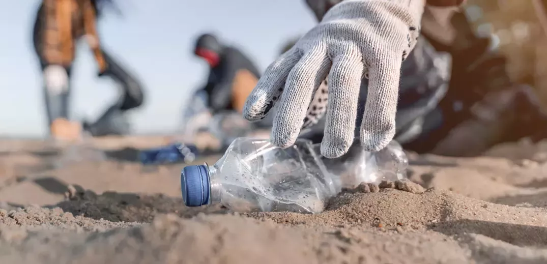 Menschen sammeln Plastikmüll am Strand auf